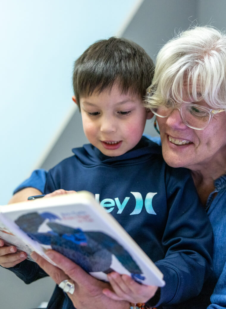 Eldery woman and child reading magazine