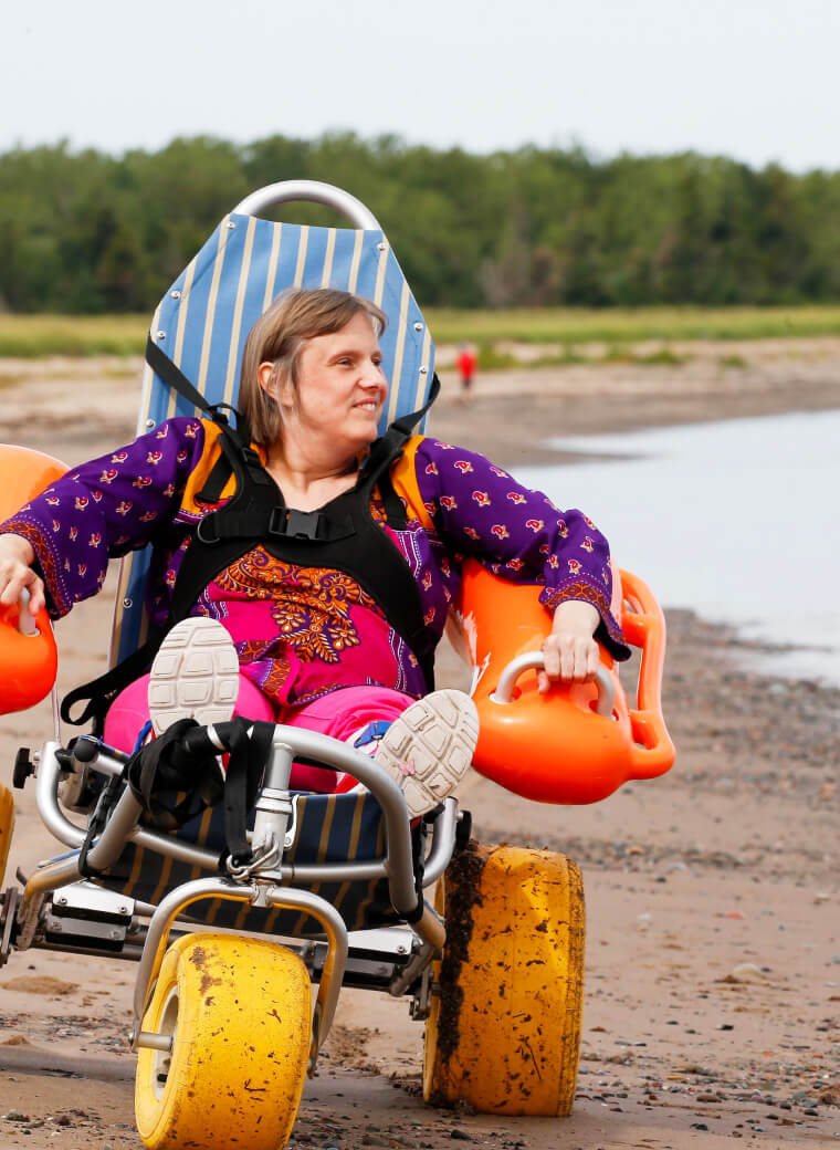 Person on beach in chair with big wheels
