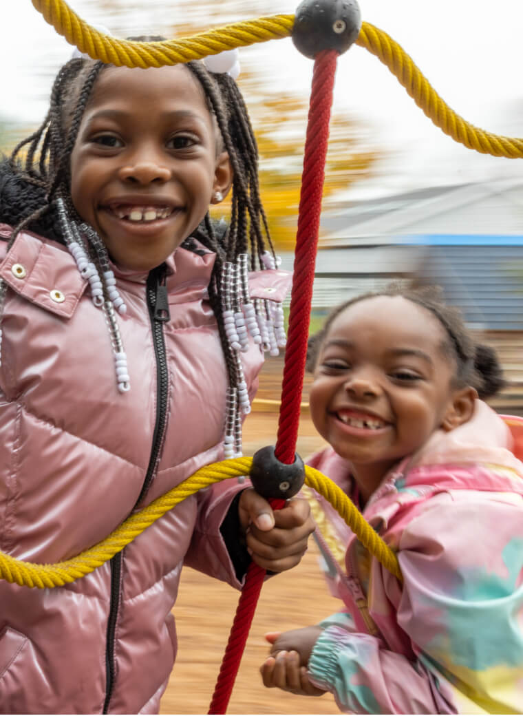 Two children playing behind a net