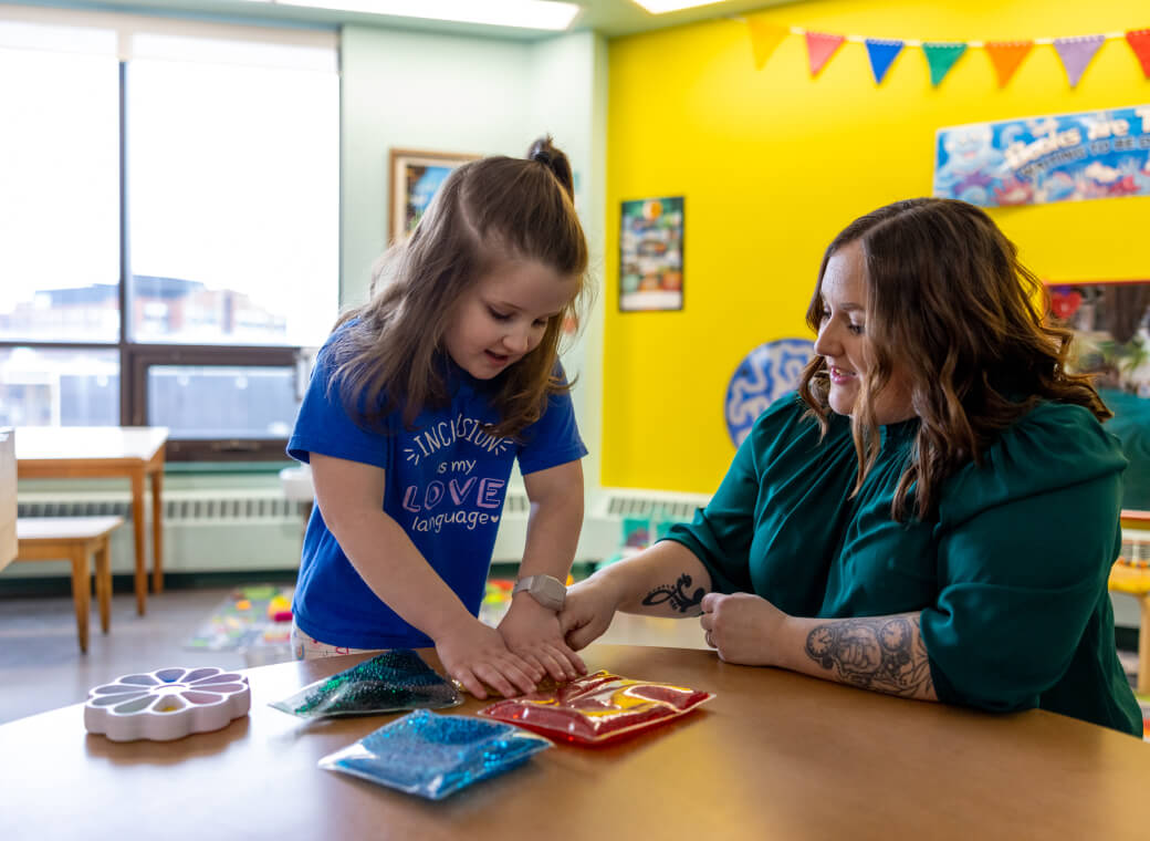 Adult helping a child with arts and crafts