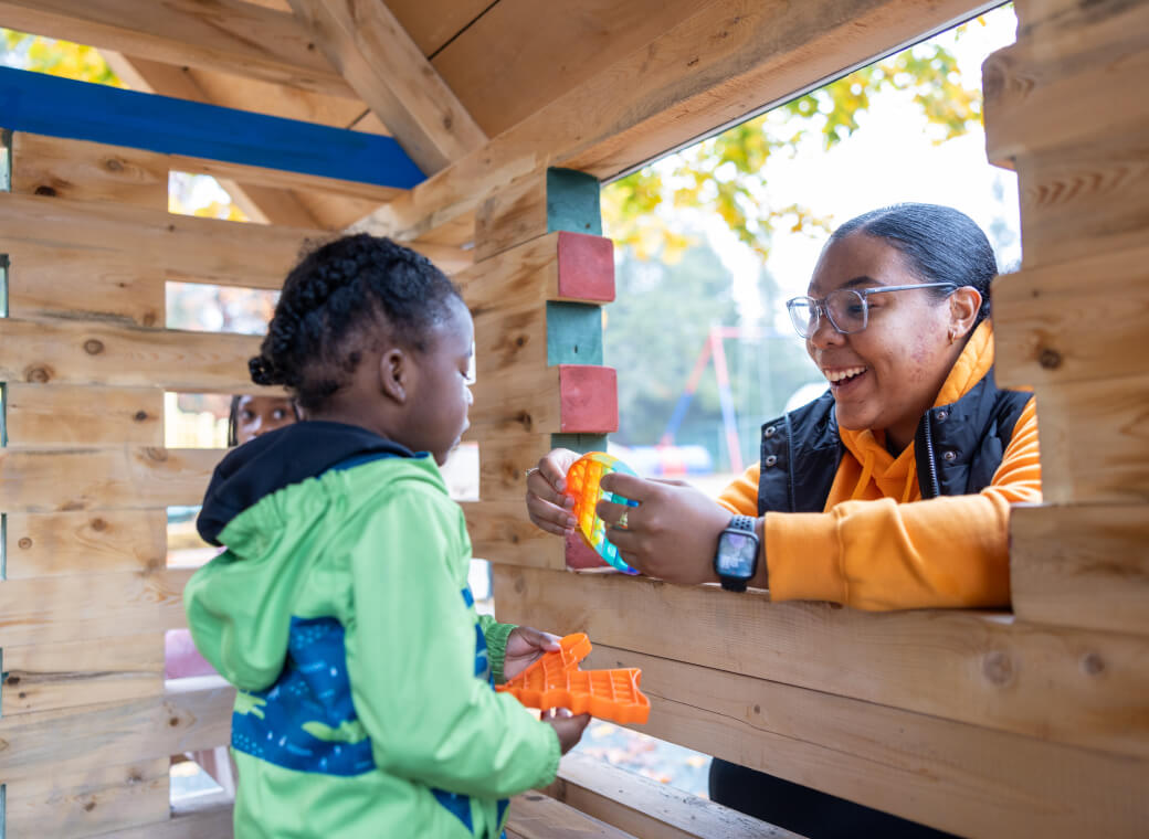Two children playing beside a window