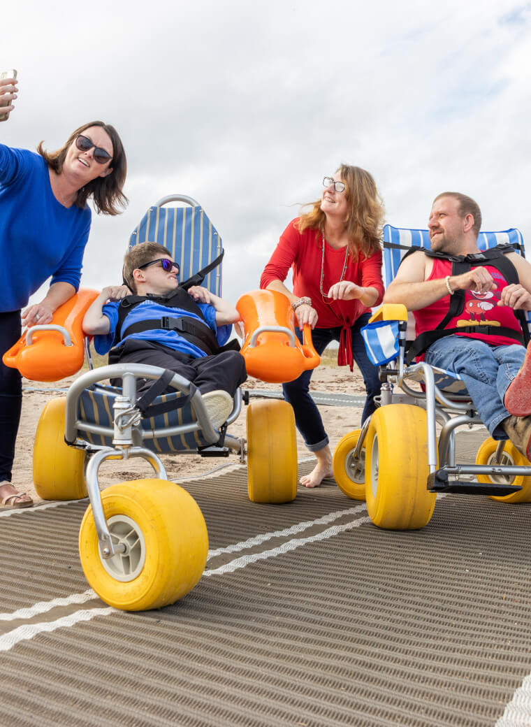 People in chairs with big wheels
