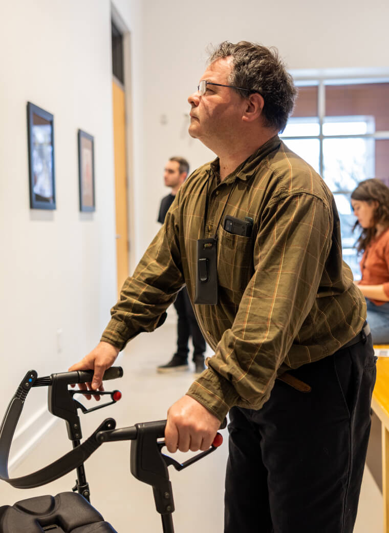 Person with walker looking at wall at a gallery